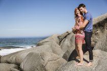 Paar steht auf Felsen am Meer und umarmt sich — Stockfoto