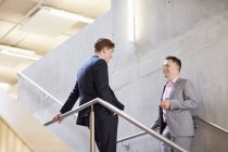 Deux hommes d'affaires bavardant sur l'escalier du bureau — Photo de stock