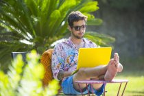 Man with feet up using laptop computer — Stock Photo
