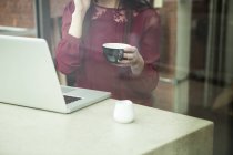 Businesswoman working with laptop in cafe — Stock Photo