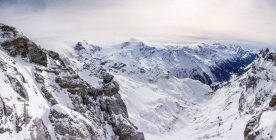 Schneebedeckte Berge mit niedrigen Wolken, Panoramablick — Stockfoto