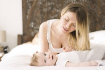 Mother and baby bonding on bed at home — Stock Photo