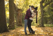 Jeune couple en forêt, embrassant — Photo de stock