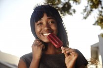 Retrato de jovem, ao ar livre, comendo gelado — Fotografia de Stock