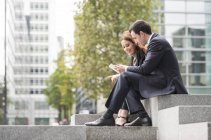 Businesspeople in city using digital tablet — Stock Photo