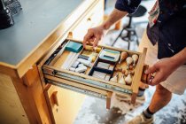 Hand greift in offene Schublade mit Geräten und Materialien in Buchkunst-Werkstatt — Stockfoto