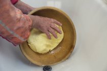 Manos de agricultora lechera dando forma a la mantequilla en un tazón, Sattelbergalm, Tirol, Austria - foto de stock