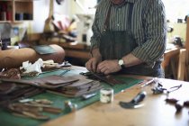 Trabalhador masculino na oficina de couro, organizando couro, seção meados — Fotografia de Stock
