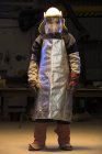 Ritratto di operaio di fonderia maschile medio adulto con visiera maschera di saldatura in fonderia di bronzo — Foto stock