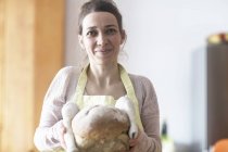 Frau hält frisch gebackenes Brot in der Hand — Stockfoto