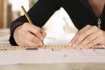 Cropped view of woman drawing blueprint — Stock Photo