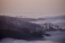 Silhouetted landscape with valley mist, Langhe, Piedmont. Italy — Stock Photo