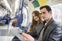 Пара на поїзді читає газету — стокове фото