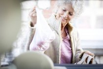 Mature femme chargement shopping dans voiture tronc — Photo de stock
