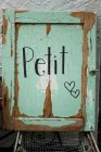 Rustic green vintage door with petit sign — Stock Photo