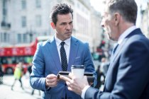 Geschäftsleute auf der Straße mit digitalem Tablet, London, Großbritannien — Stockfoto