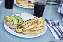 Hamburguesa y papas fritas con cola en la mesa de la cafetería, Nueva York, Estados Unidos - foto de stock