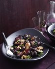 Миска теплого бурякового салату на столі з червоним вином — стокове фото