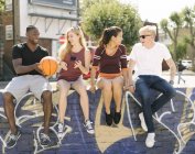 Basketballfreunde sitzen plaudernd im städtischen Skatepark — Stockfoto
