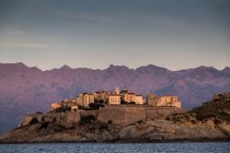 View of sea and Calvi on headland at dusk, Corsica, France — Stock Photo