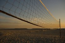 Beach volleyball net with sunset sky — Stock Photo