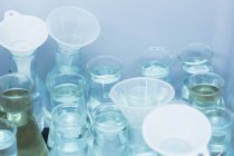 Funnels and beakers filled with liquid — Stock Photo