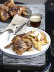 Жареные острые куриные крылышки с бокалом пива — стоковое фото