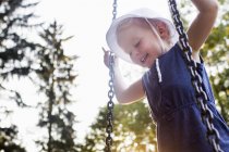 Baby girl playing on park swing, low angle view — Stock Photo