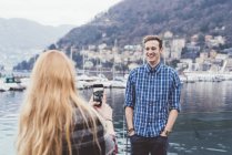 Giovane donna sul lungomare fotografo fidanzato, Lago di Como, Italia — Foto stock