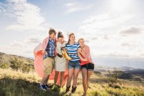 Young man and female friends wrapped blanket on hill, Bridger, Montana, USA — Stock Photo