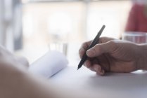 Mann schreibt Notizen auf Schreibtisch, Nahaufnahme der Hand — Stockfoto