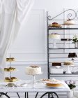 Seleção de bolos na mesa de chá tradicional e prateleiras — Fotografia de Stock