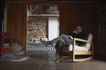Средний взрослый мужчина читает книгу в гостиной — стоковое фото