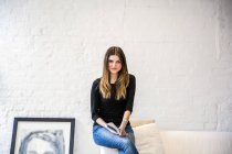 Porträt einer jungen Frau in stilvoller Wohnung mit Buch — Stockfoto
