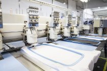 Linhas de máquinas de bordar programadas velocidade costura na fábrica de roupas — Fotografia de Stock