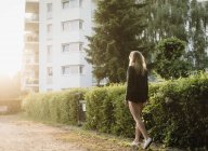 Jovem mulher ao ar livre, andando ao longo da rua, visão traseira — Fotografia de Stock