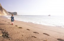 Chica disfrutando de la playa, Hombre O 'War Beach, Dorset - foto de stock