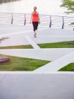 Вид сзади на женщину в спортивной одежде на благоустроенной городской территории — стоковое фото