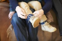 Adulto aiutare il bambino con le scarpe, colpo ritagliato — Foto stock
