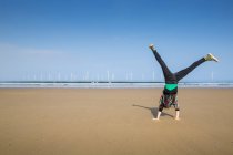 Mulher madura fazendo cartwheel na praia Redcar, North Yorkshire, Reino Unido — Fotografia de Stock