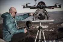 Зрелый человек готовится к полету дрона, Стреза, Пьемонт, Италия — стоковое фото