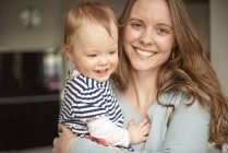 Portrait of young woman and baby daughter at home — Stock Photo