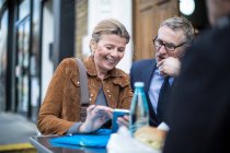 Business people at pavement cafe having working lunch — Stock Photo