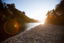 Мальовничий вид на березі річки на заході сонця — стокове фото
