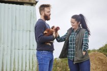 Junges Paar auf Hühnerfarm hält Hühner — Stockfoto