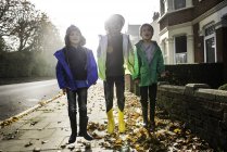 Três meninos, ao ar livre, pulando na rua — Fotografia de Stock