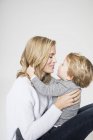 Portrait of mother and son against white background, face to face, smiling — Stock Photo