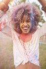 Portrait of young woman at festival, covered in colourful powder paint — Stock Photo