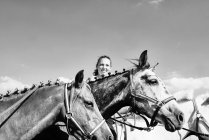 B & W image of woman with horses — Stock Photo