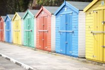 Fila di capanne da spiaggia in legno multicolore — Foto stock